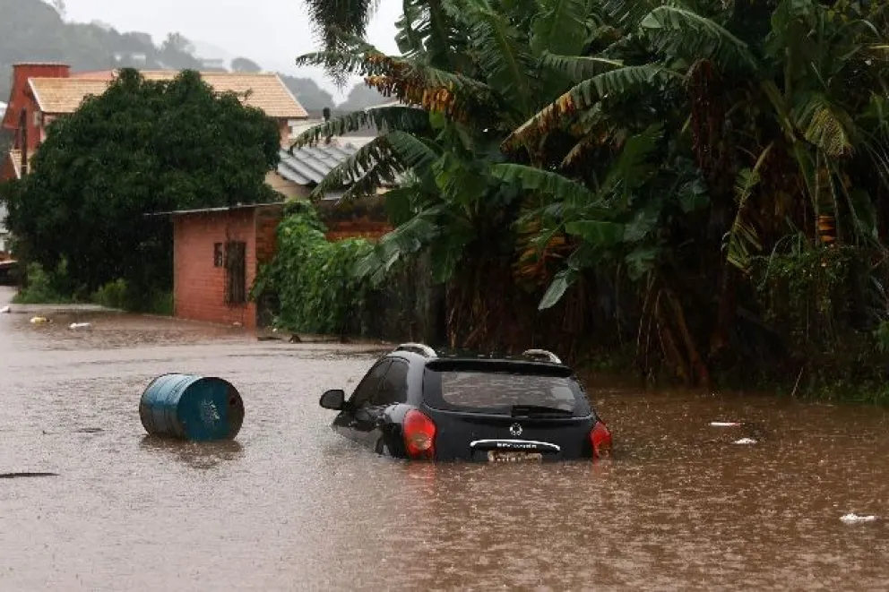 Fotografía cedida por el Ayuntamiento de Santa María, que muestra a un grupo de personas que se transportan en una canoa en una calle inundada este miércoles, en Santa María, Estado de Río Grande del Sur (Brasil). 