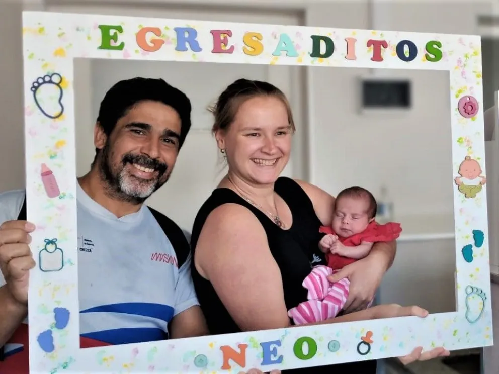 La pequeña en los brazos de sus padres, tras recibir el alta médica. //Foto: Esteban González.
