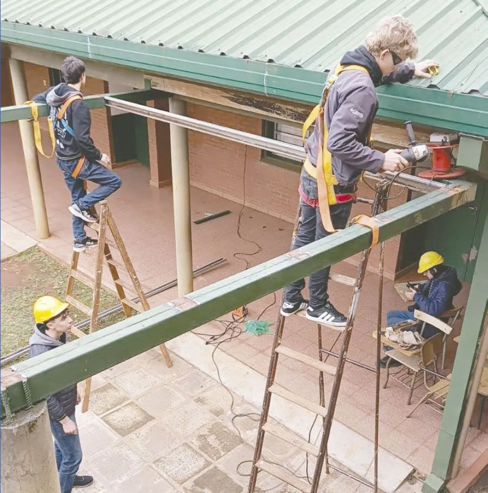 Estudiantes aplican sus conocimientos en la construcción del invernadero.