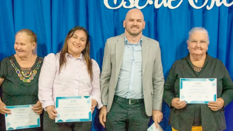 Las hermanas -una a cada lado de la foto- en el día de su graduación junto a su compañera y su profesor.