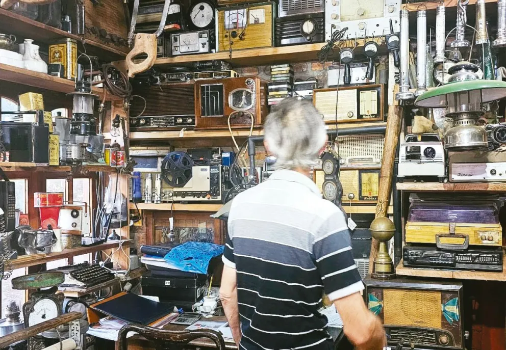 César Daniel Hippler en su casa de Puerto Leoni, rodeado de objetos antiguos que conserva y restaura con el sueño de convertir su colección en un museo abierto a la comunidad. //Foto: Esteban González.