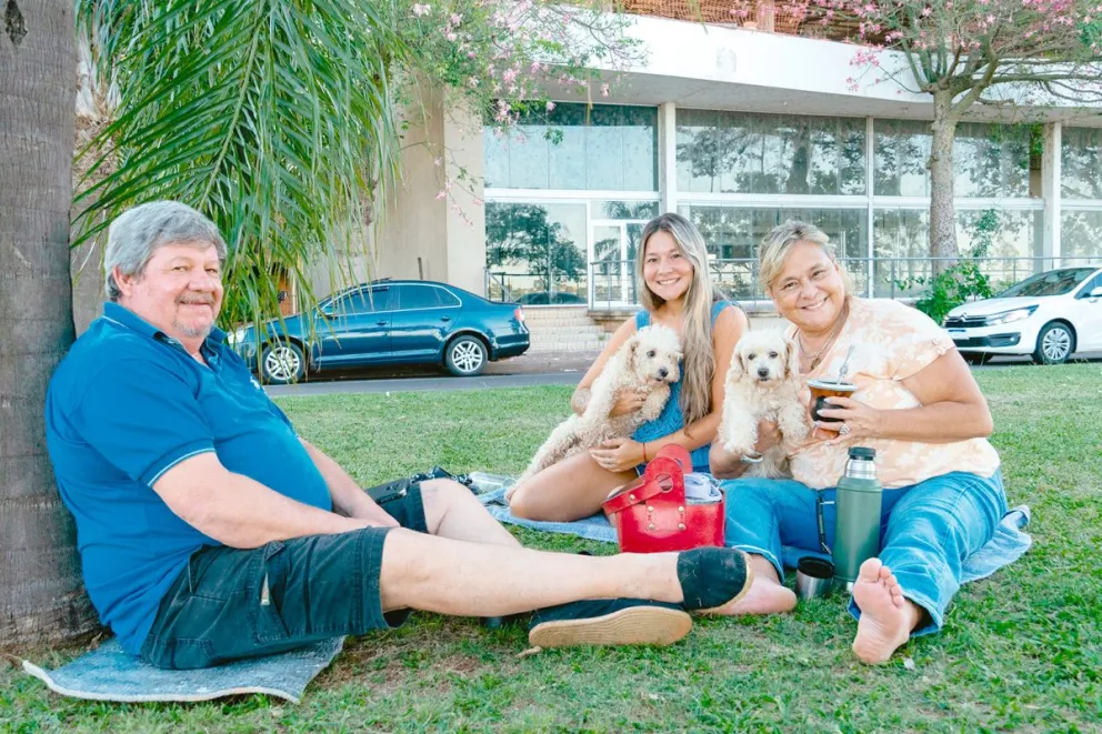 Ricardo Luna, Mirtha Mascareño y Nicole Luna, a pleno en el césped y con las mascotas. Grato paseo con los mates.