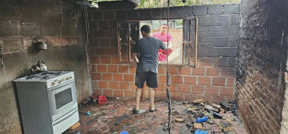 Daniel junto a vecinos y allegados trabajan entre los escombros para limpiar el terreno tras el voraz incendio que consumió la vivienda familiar en el barrio Timbó.