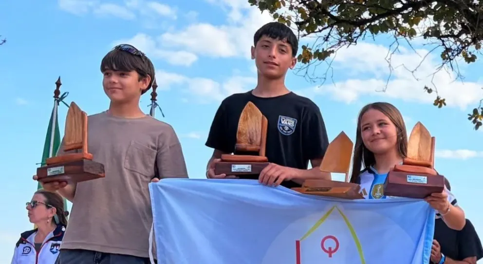 Kevin Méndez, Bautista Jendrika y Simona Moreno, en el podio de Optimist timoneles de la Copa Mercosur, disputada en el club náutico San Bernardino.