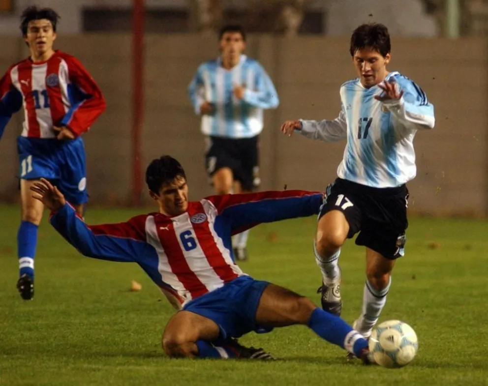 Messi encara y, de fondo y con la 11, Hobecker lo admira.